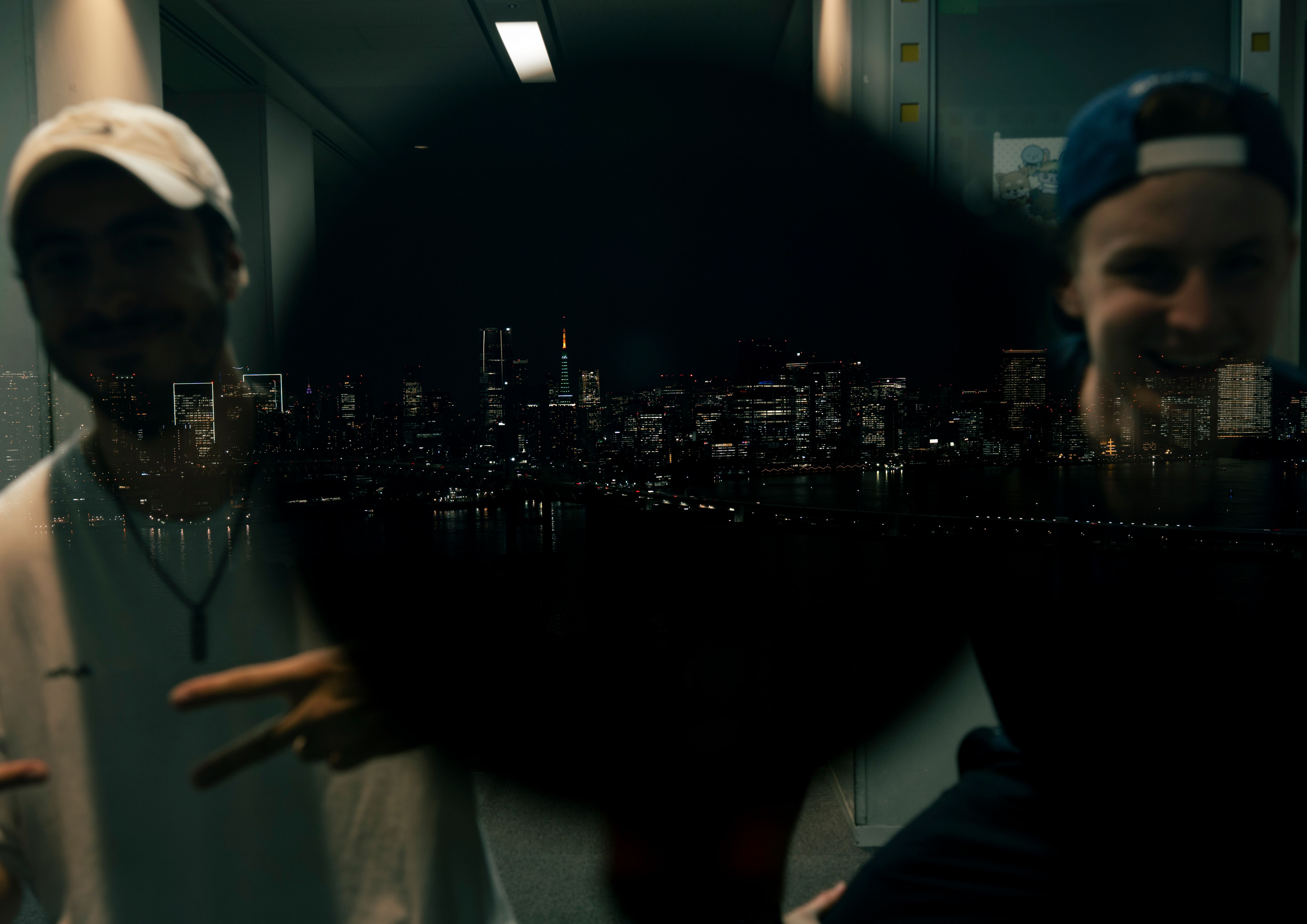 Mirror picture with the tokyo skyline in the middle and 2 friends left and right